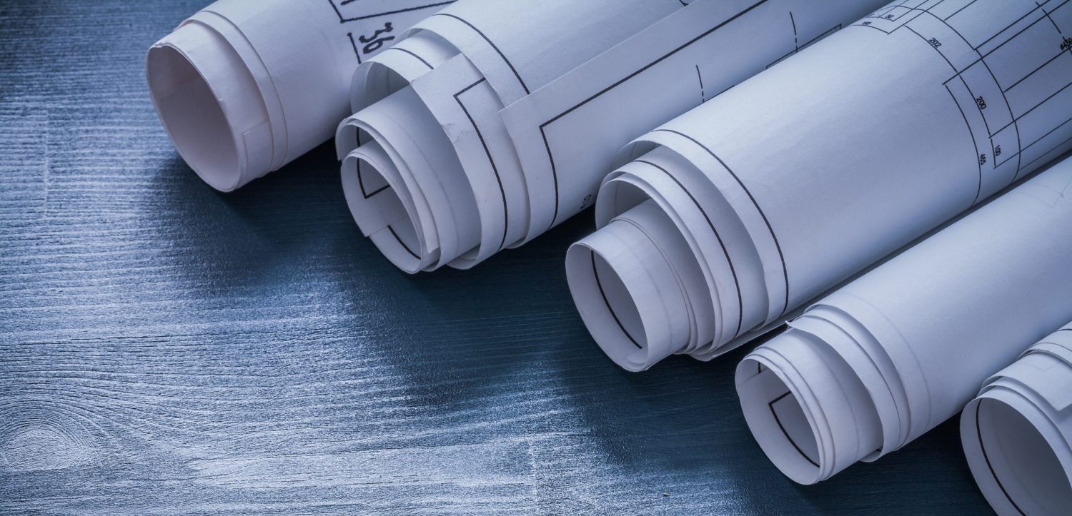 five rolls of white blueprints